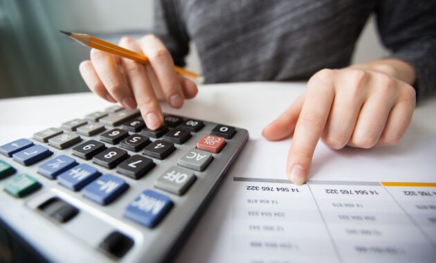 Closeup of Accountant Hands Counting on Calculator